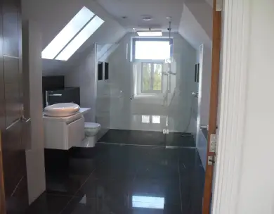 Luxury loft bathroom renovation with skylight and modern tiling in Chigwell Essex