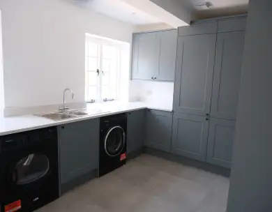 Modern bespoke utility room with fitted cabinetry and laundry area in Loughton Essex