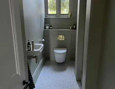 Modern cloakroom bathroom with wall-mounted sink and contemporary tiling in Loughton Essex