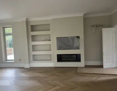 Luxury living room with bespoke media wall and herringbone flooring in Loughton Essex