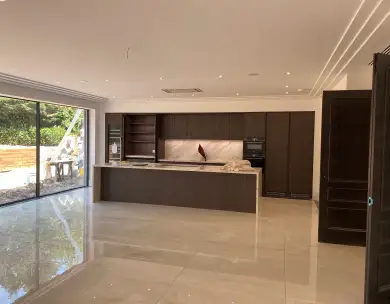 Luxury open plan kitchen interior with bespoke cabinetry and large sliding doors in Chigwell Essex