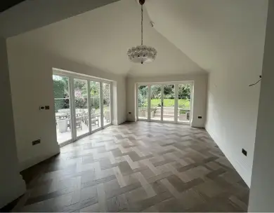 Luxury open plan extension interior with herringbone flooring and bifold doors in Loughton Essex